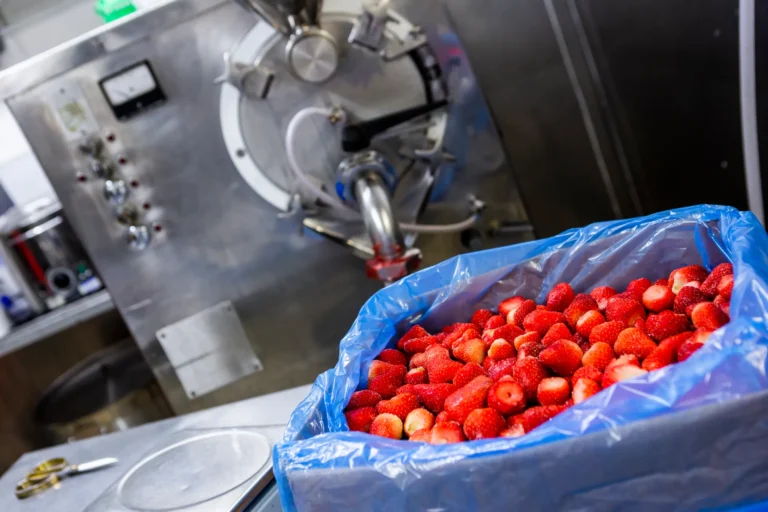 Machine with a large bin of strawberries.