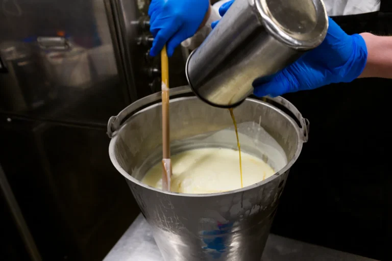 Pouring liquid into large mixing bucket